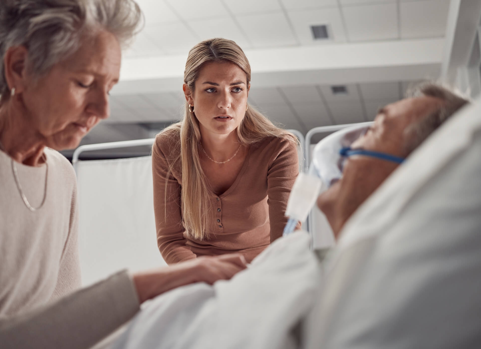 Senior man sick in the hospital with family.